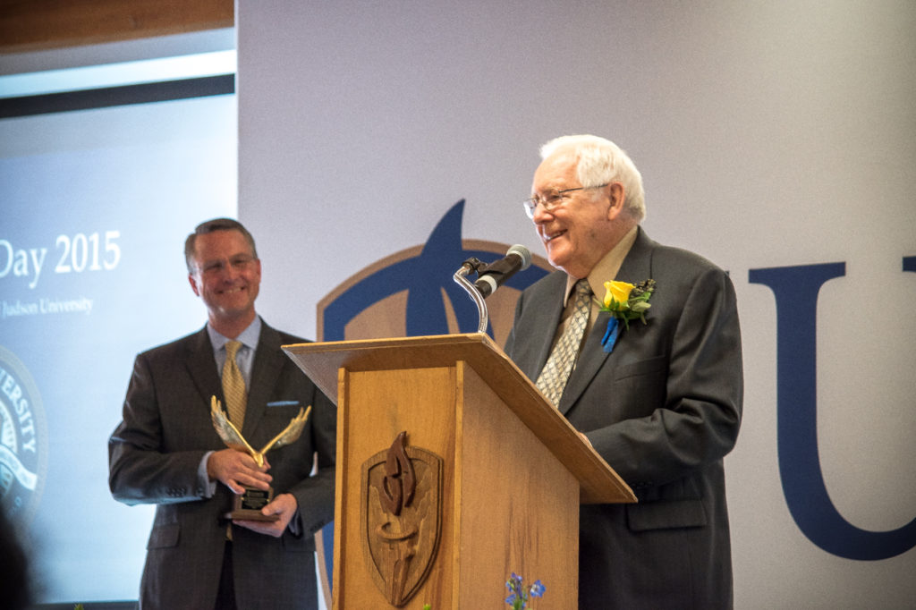 James Didier speaking at a Judson University podium