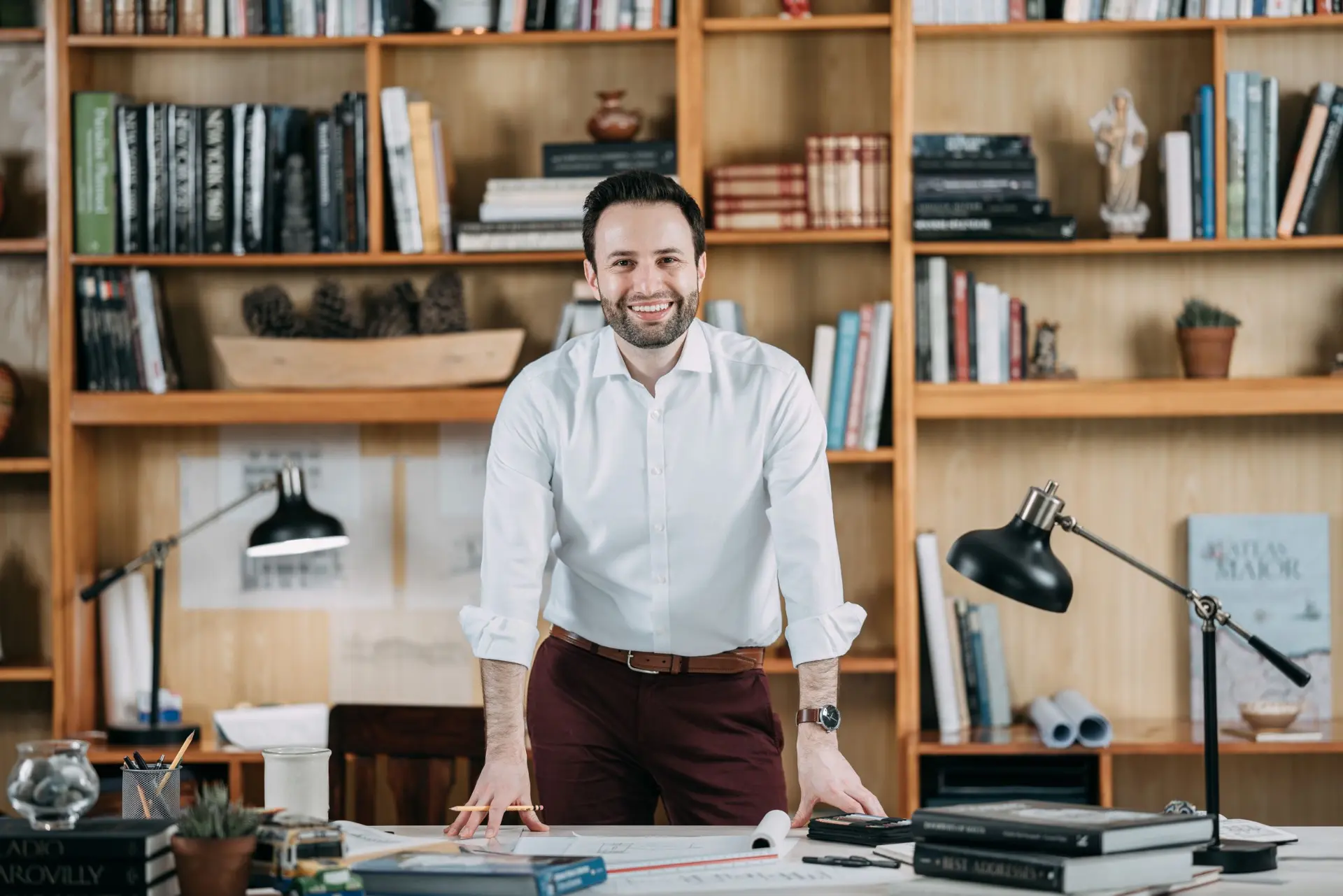Portrait of Rodrigo Bollat Montenegro standing at a drawing table in a library