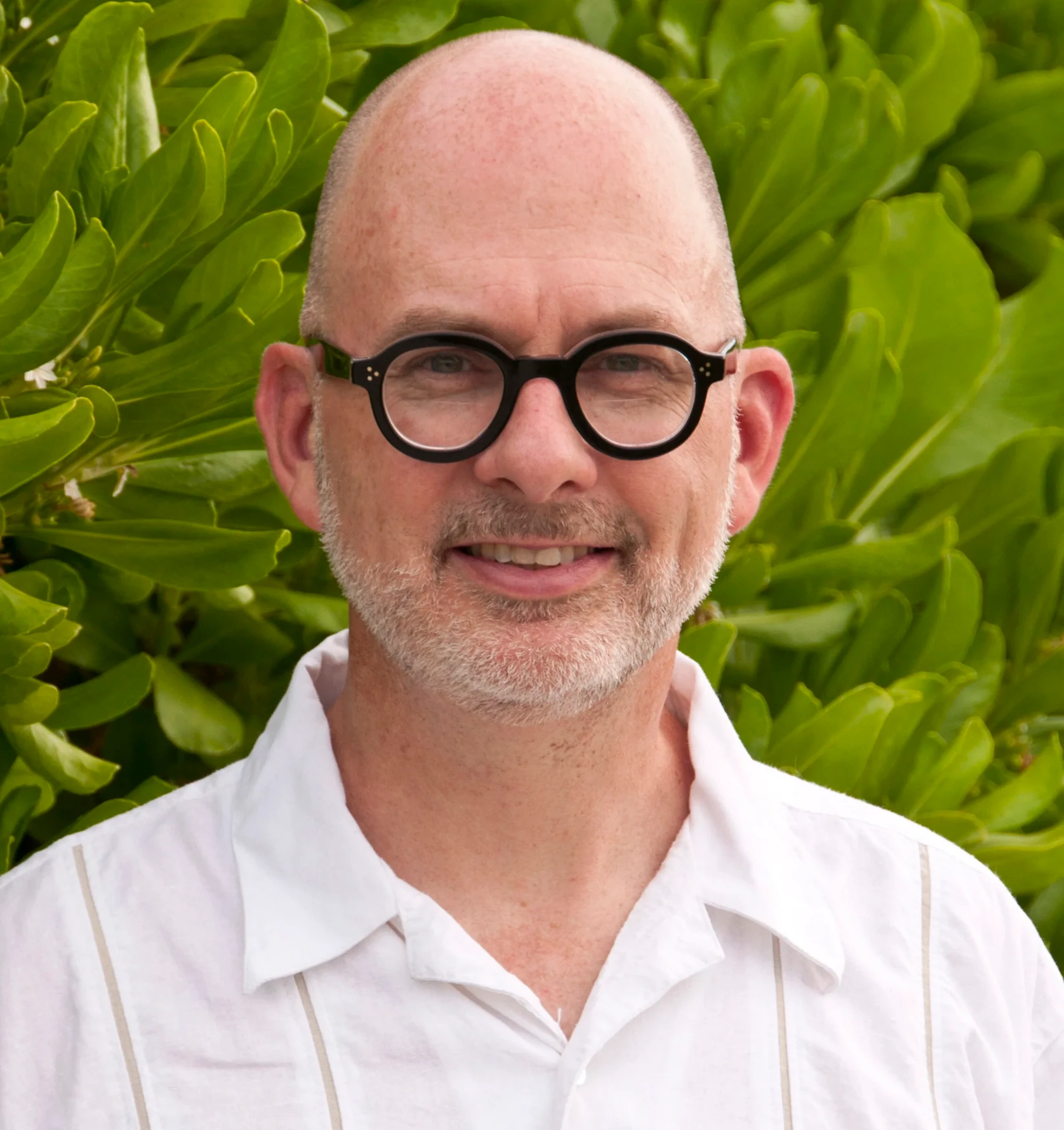 Portrait of Steve Mouzon outdoors in front of green foliage